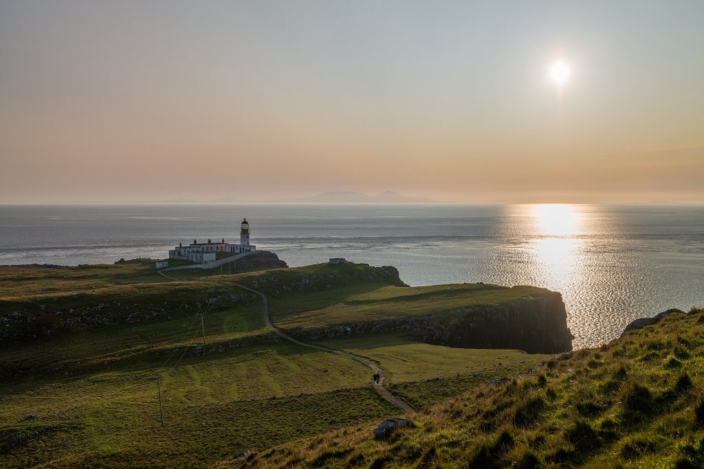Neist Points fyr på klipphalvön längst västerut på Skye, i lågt kvällsljus över Minch