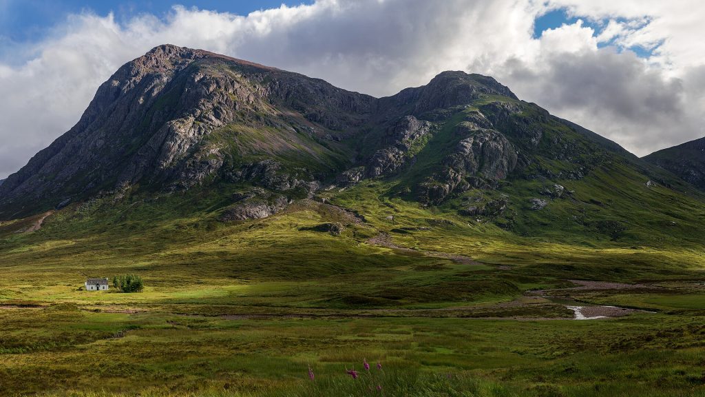 Buachaille Etive Mòr med den vita stugan Lagangarbh framför bergsfoten vid infarten till Glencoe