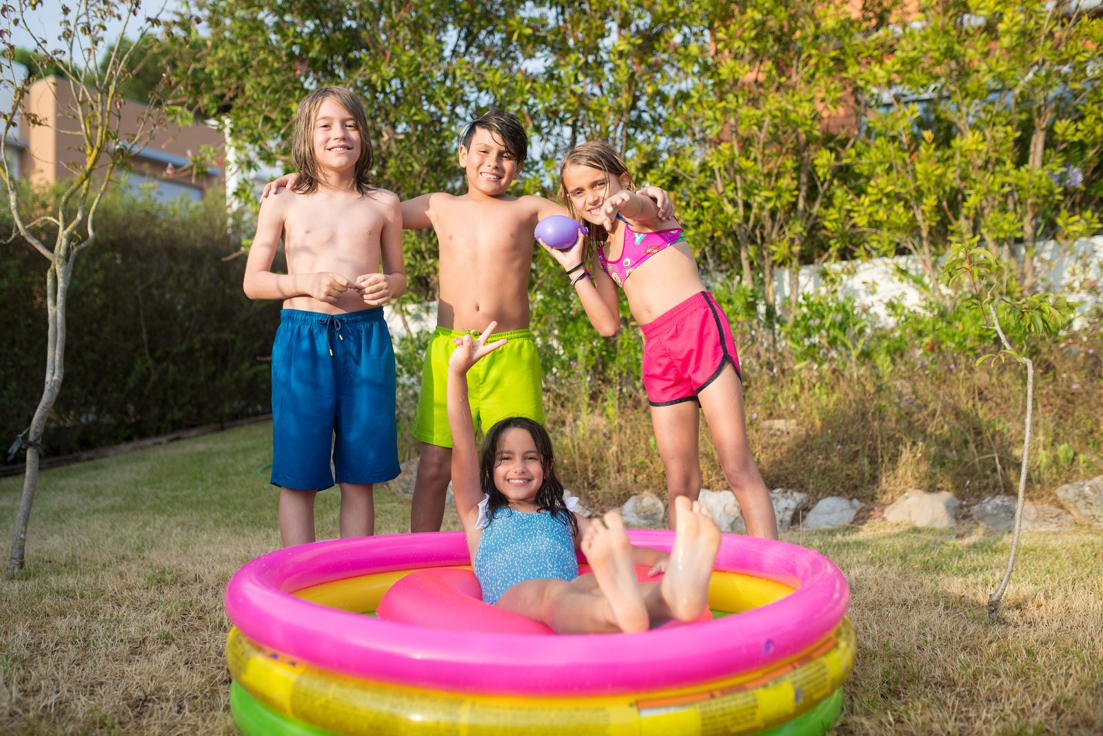 Barn badar i en uppställbar pool en solig sommardag