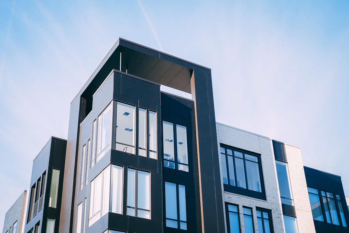 Modern nybyggd flerbostadshusfasad mot blå himmel
