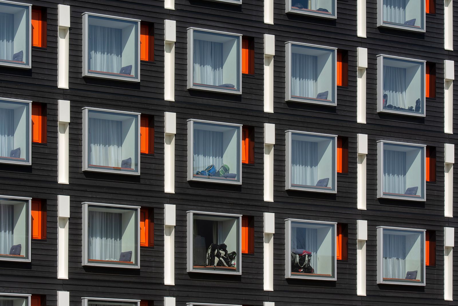 Fasad på ett modernt studentbostadshus med rader av likadana lägenheter och stora fönster