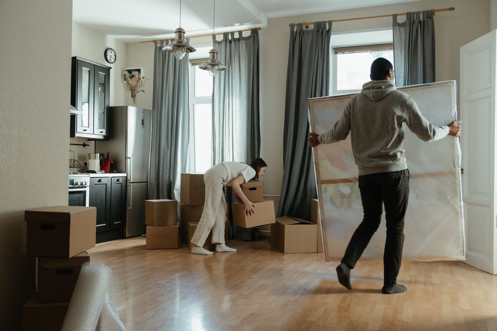 Ungt par som flyttar in i en lägenhet med flyttkartonger