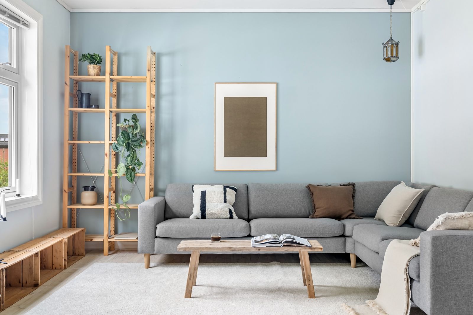 Ljust och stadat skandinaviskt vardagsrum med soffa och hyllor