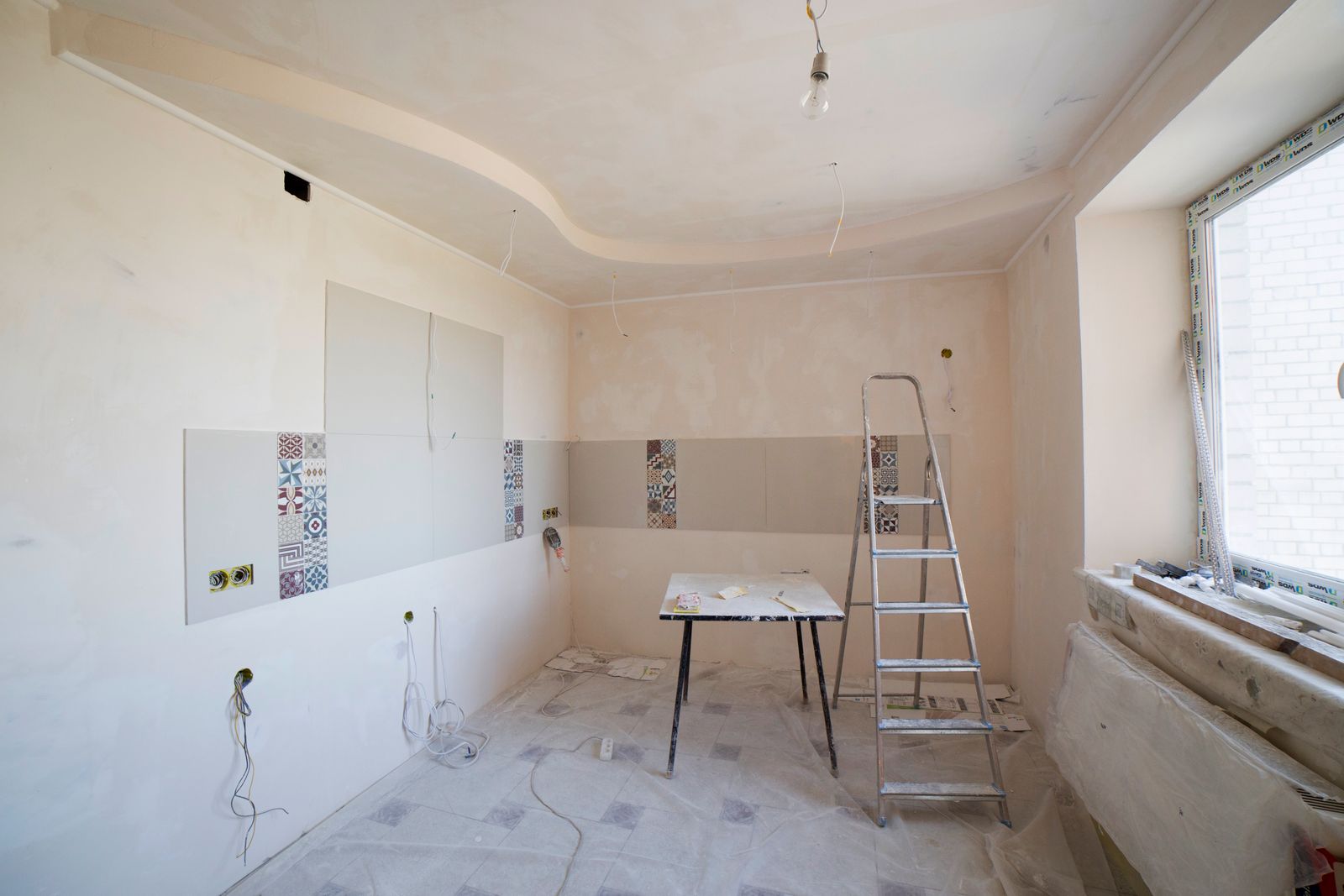 Kok under renovering med verktyg och plastskyddade ytor