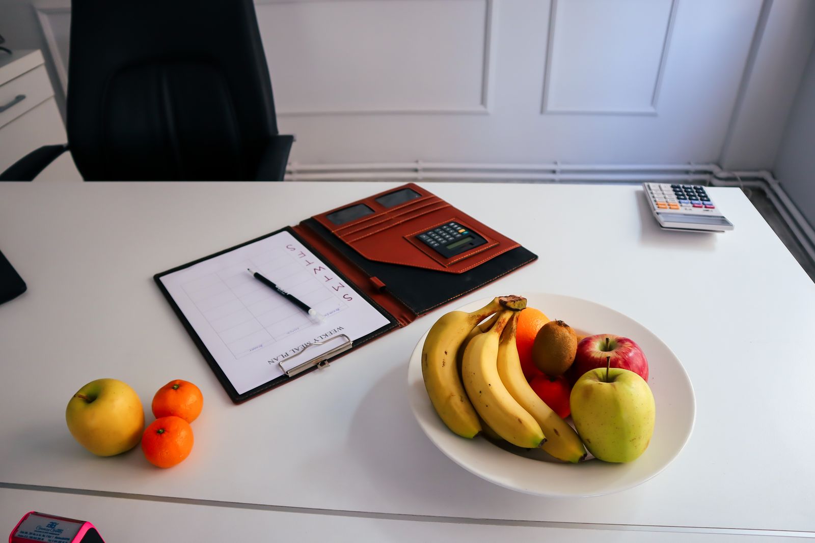 Skål med frukt på ett kontorsskrivbord