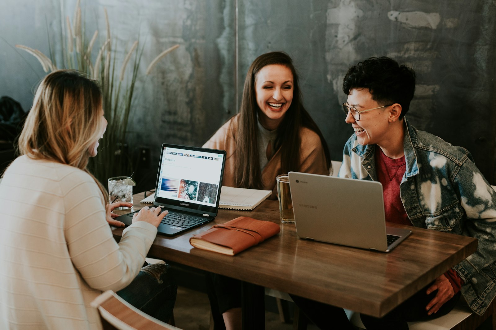 Young professionals collaborating at a table with laptops