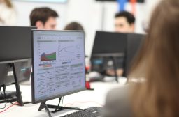 Team monitoring data dashboards on office screens