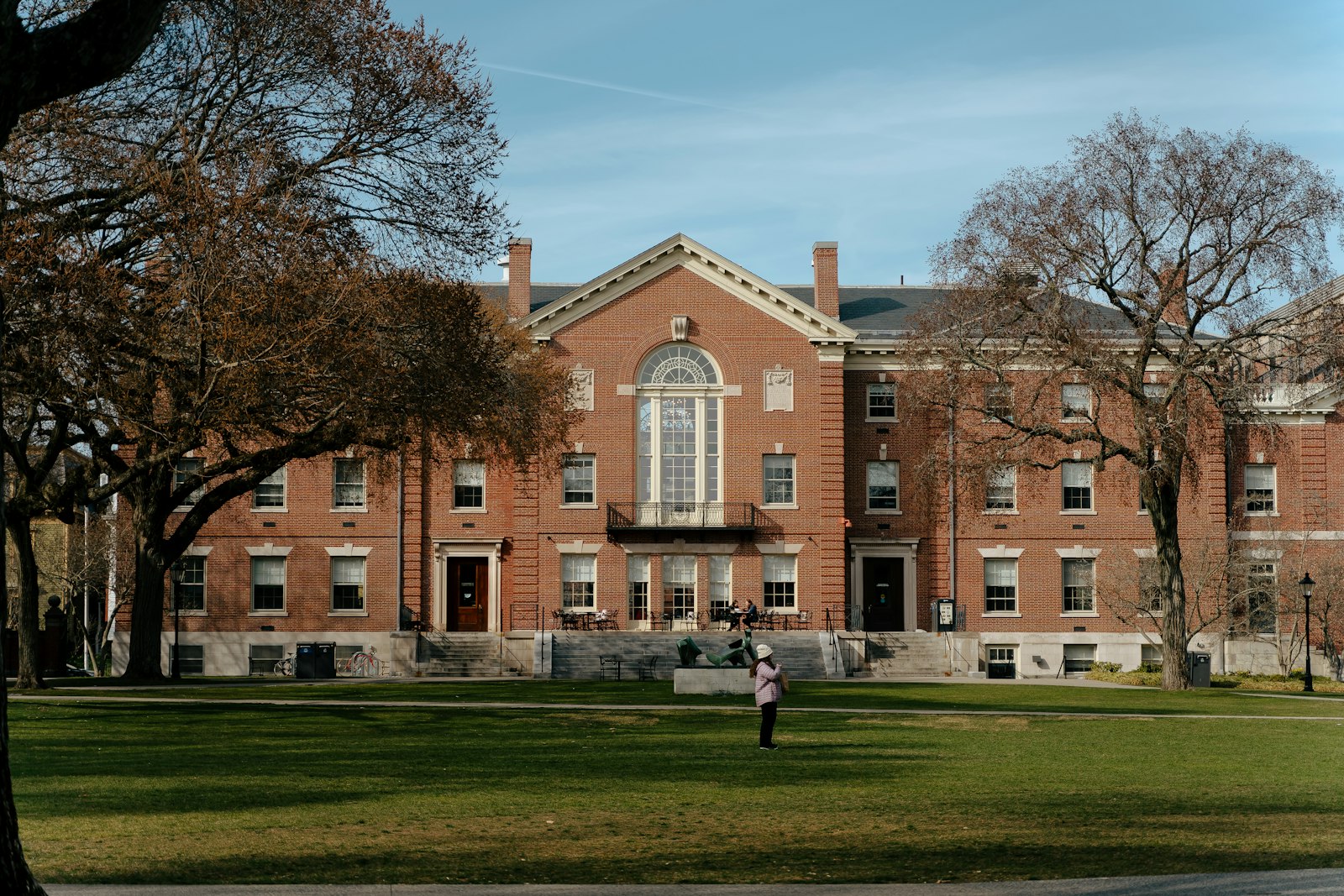 Tegelbyggnad på ett amerikanskt universitetscampus med gräsmatta och blå himmel