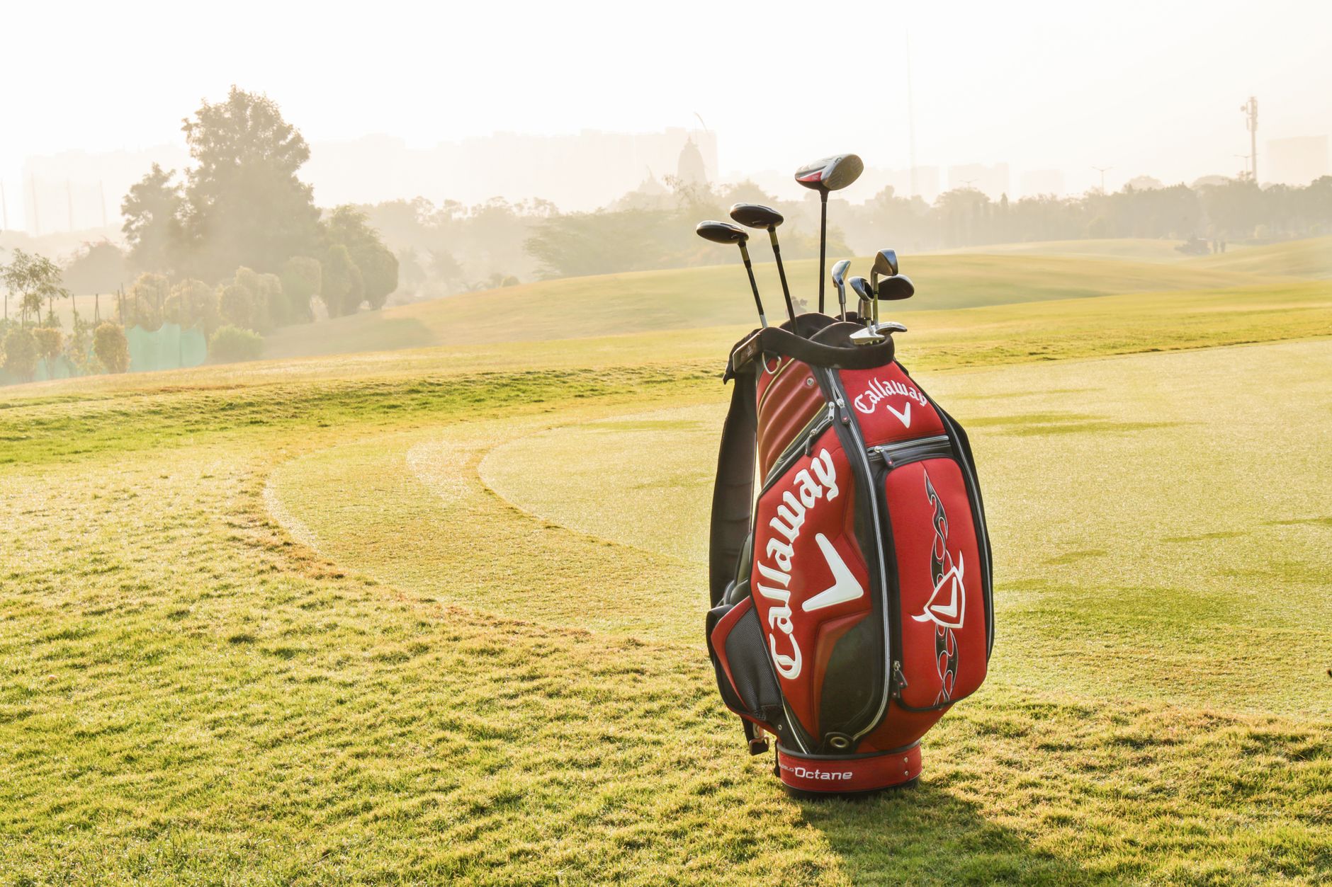 Fullpackad golfbag med klubbor på en solig golfbana