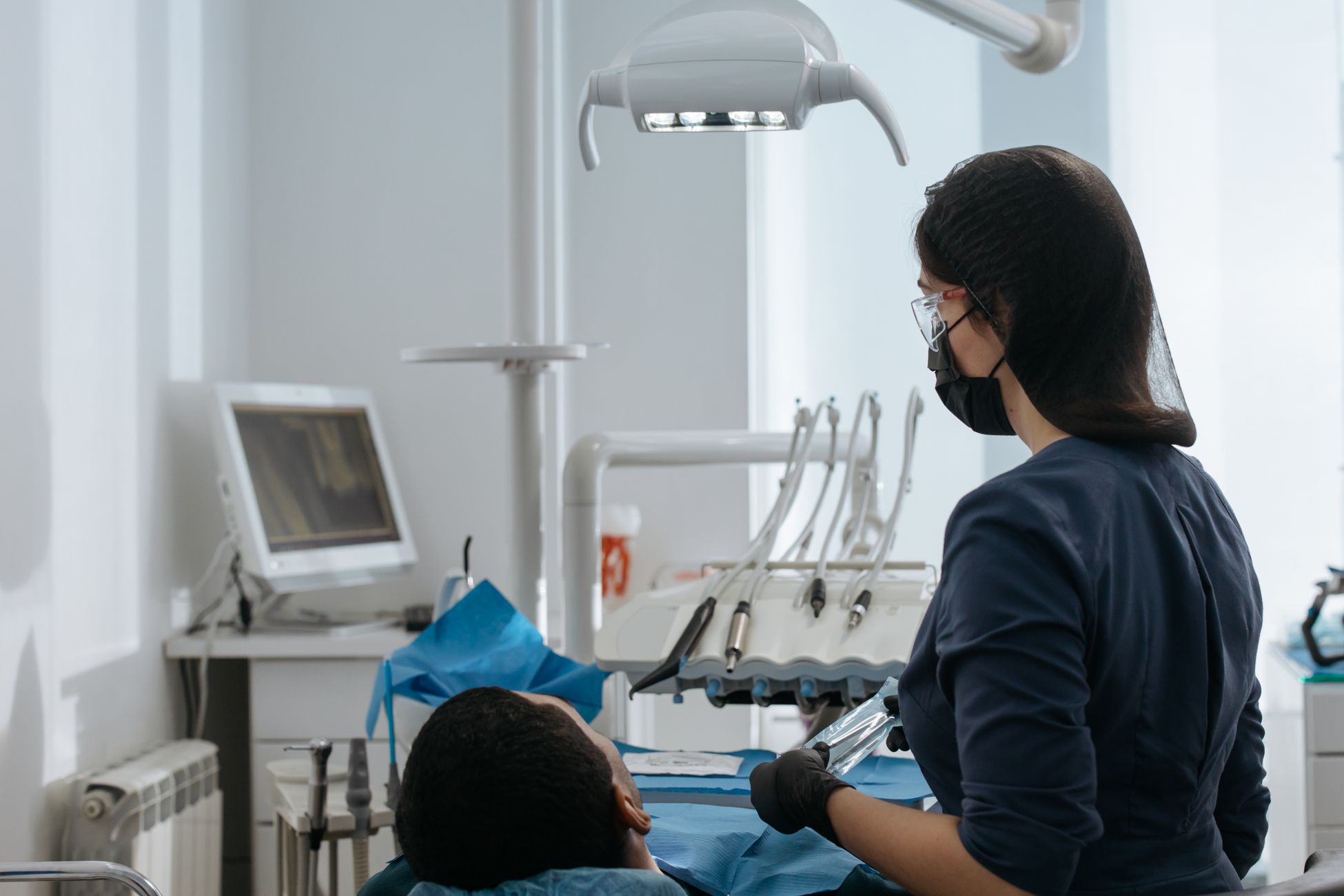 Tandlakare undersoker en patients tander i behandlingsstol