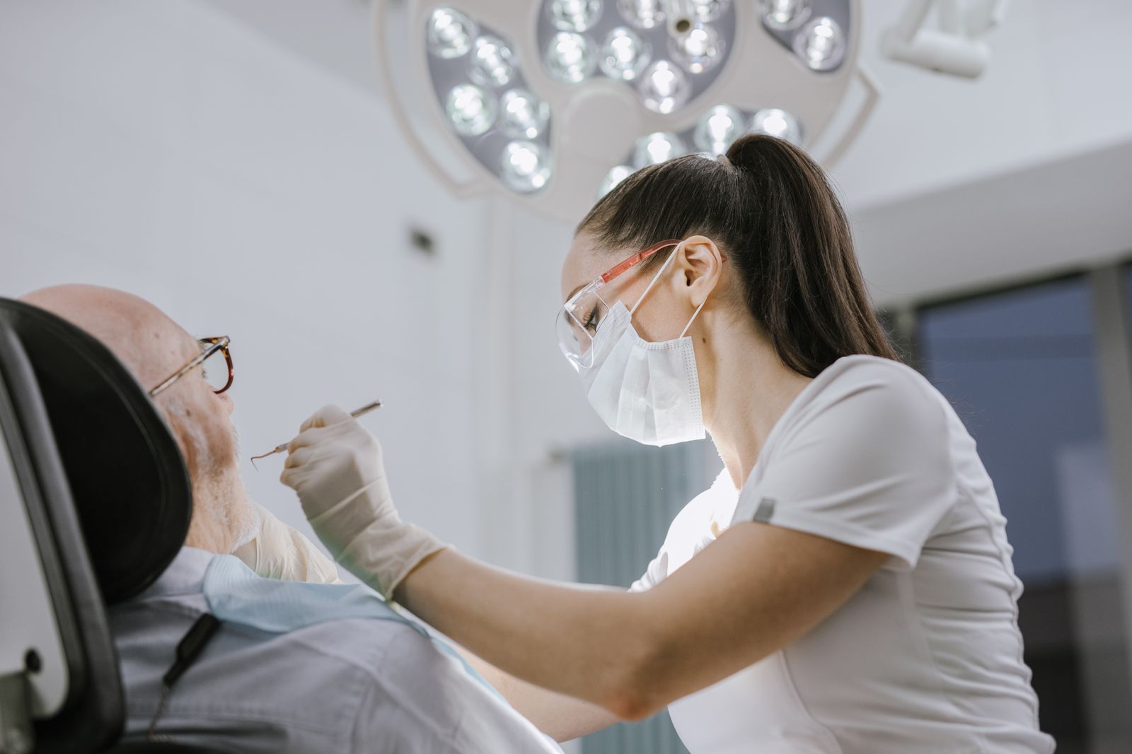 Tandlakare undersoker en patient i behandlingsstol