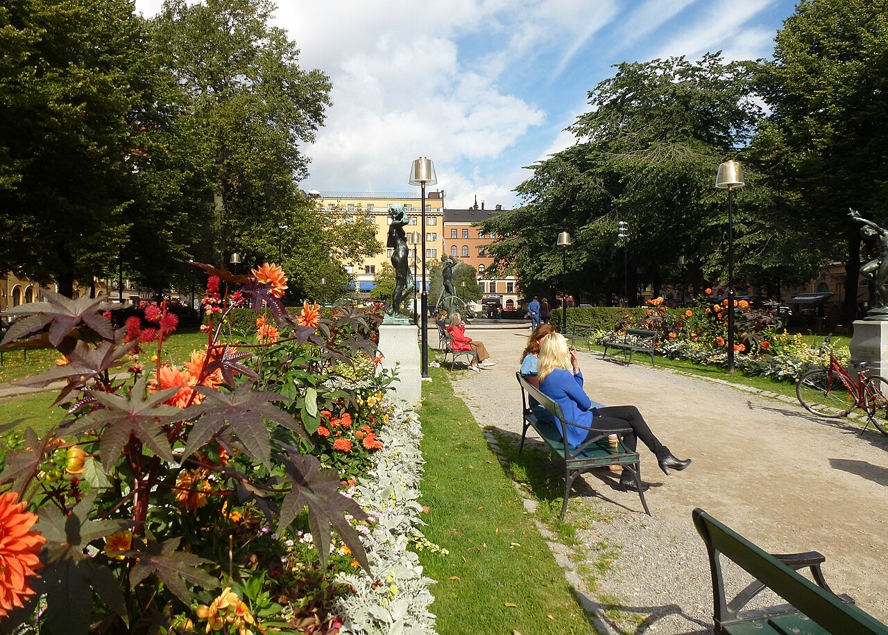 Parken på Mariatorget med blommande rabatter och bänkar