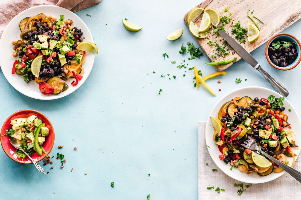 Sallad med svarta bönor, kikärter, avokado och lime i vita skålar