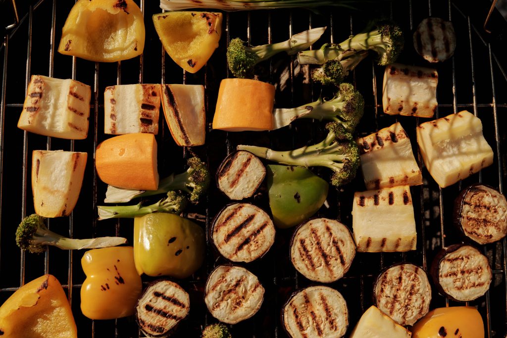 Grillade grönsaker, bland annat aubergine, paprika och broccoli, på ett galler