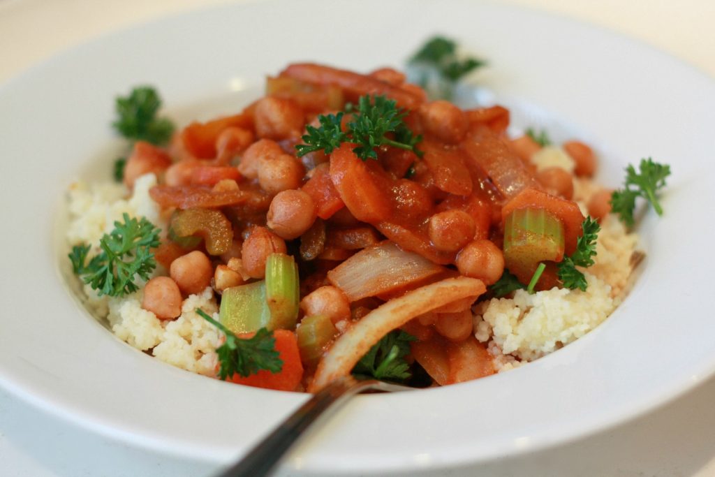 Kikärtsgryta med selleri, lök, morot och tomat serverad på couscous