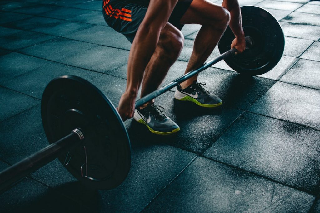 Person lyfter en skivstång i marklyft-position på ett gym
