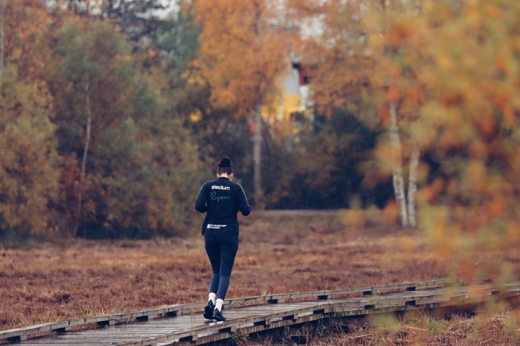 Löpare på en träspång genom höstfärgad skog