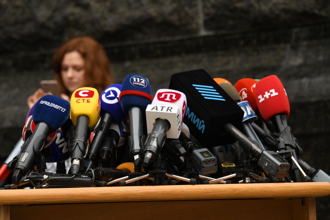 Rad av mediemikrofoner uppställda vid en presskonferens