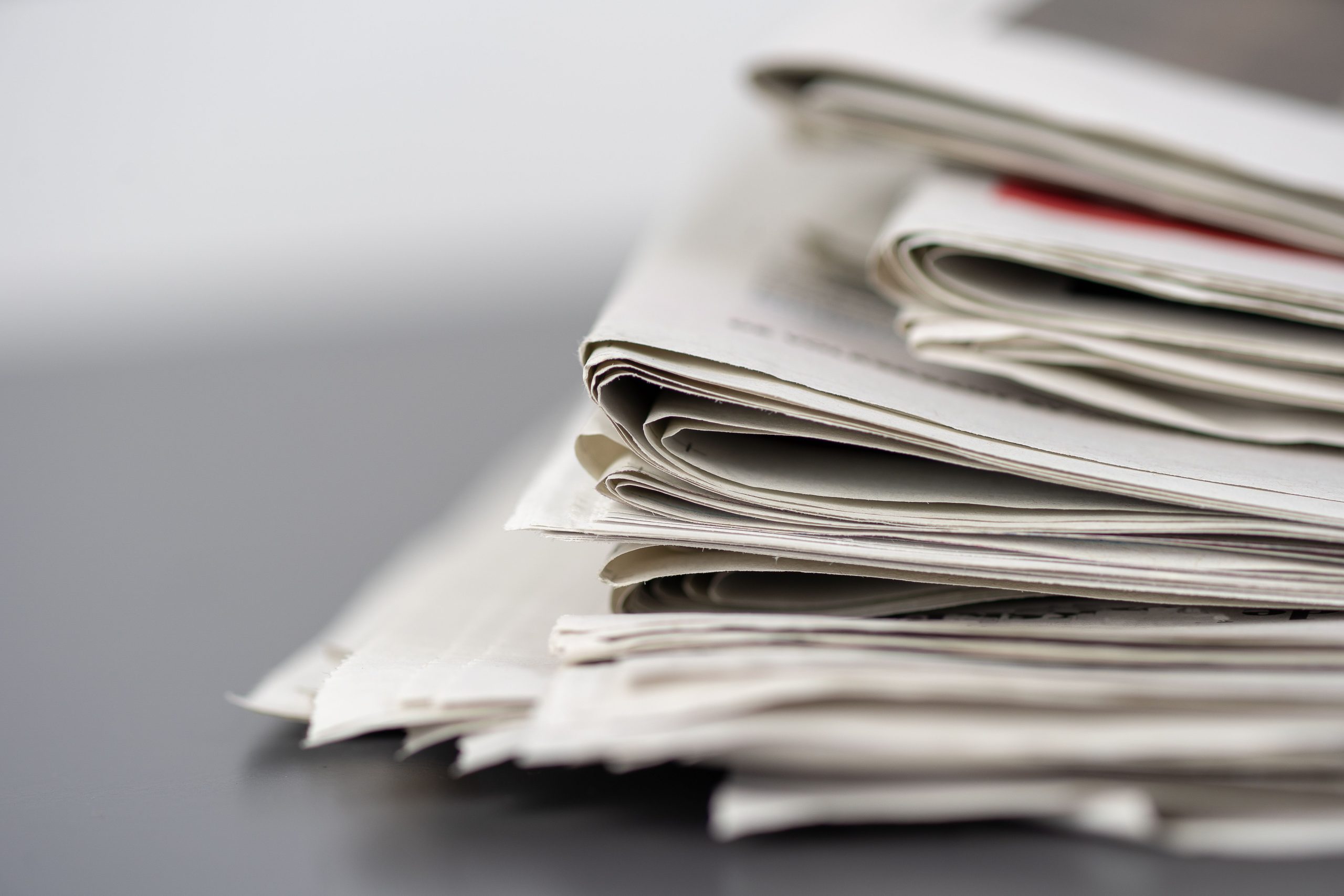 Bunt med hopvikta tidningar, symbol för press och media