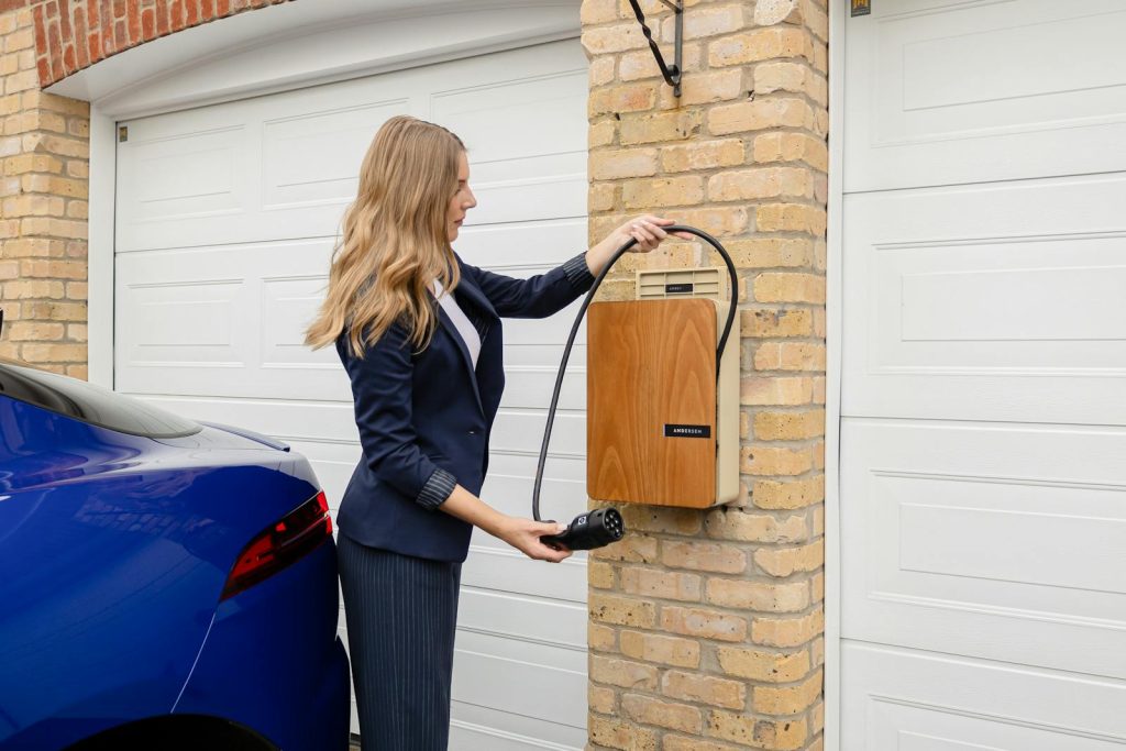 Elbil som laddas via laddbox hemma i garaget