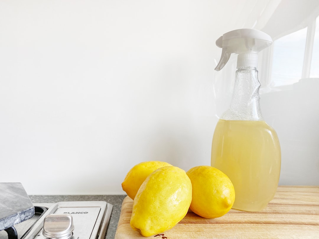 Sprayflaska med hemmagjord citrusrengöring och citroner på en köksbänk