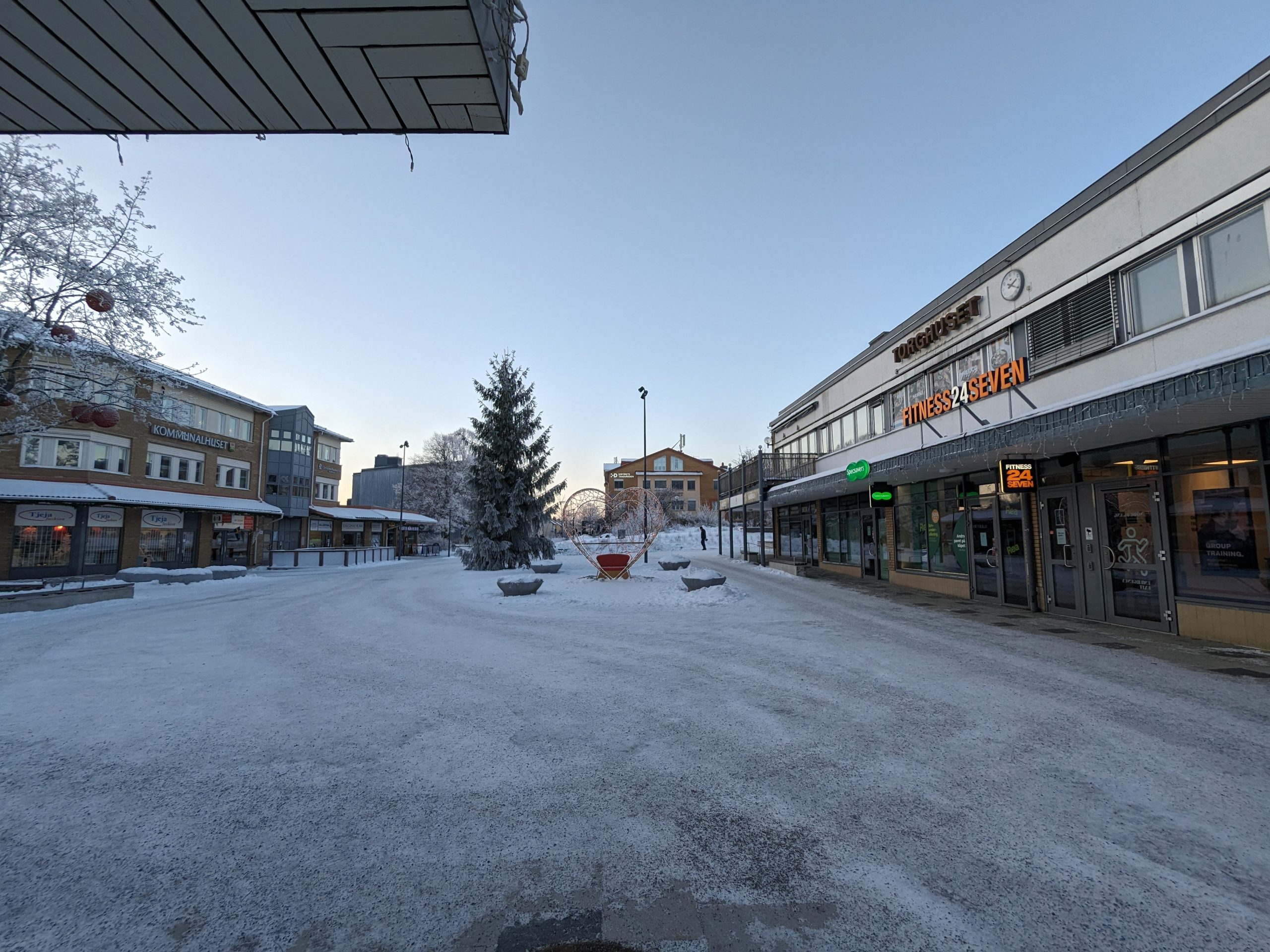 Vallentuna centrum en vinterdag med snötäckt torg, kommunalhuset till vänster och Torghuset till höger
