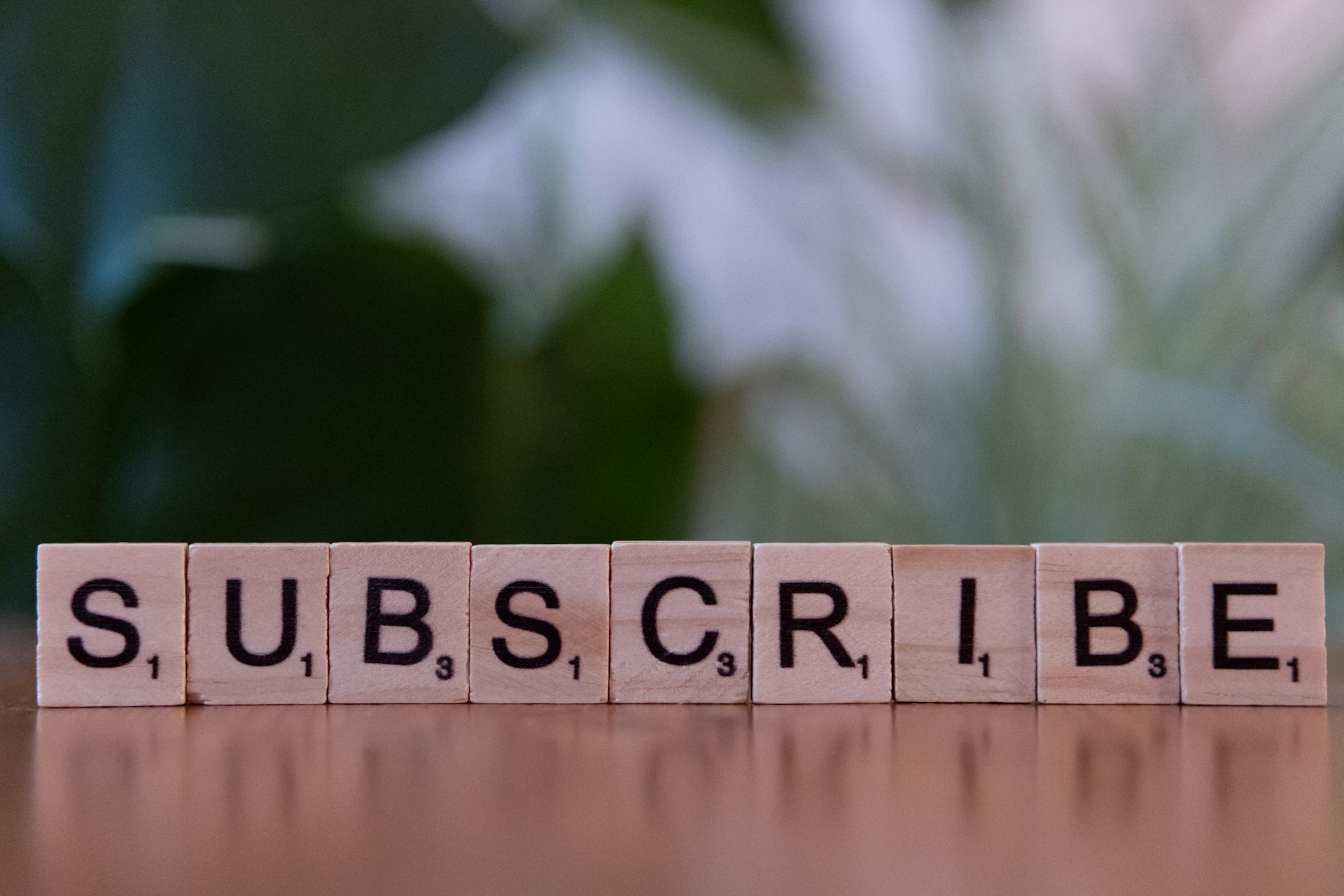 Träklossar som stavar subscribe på ett bord, symbol för opt-in och e-postlista
