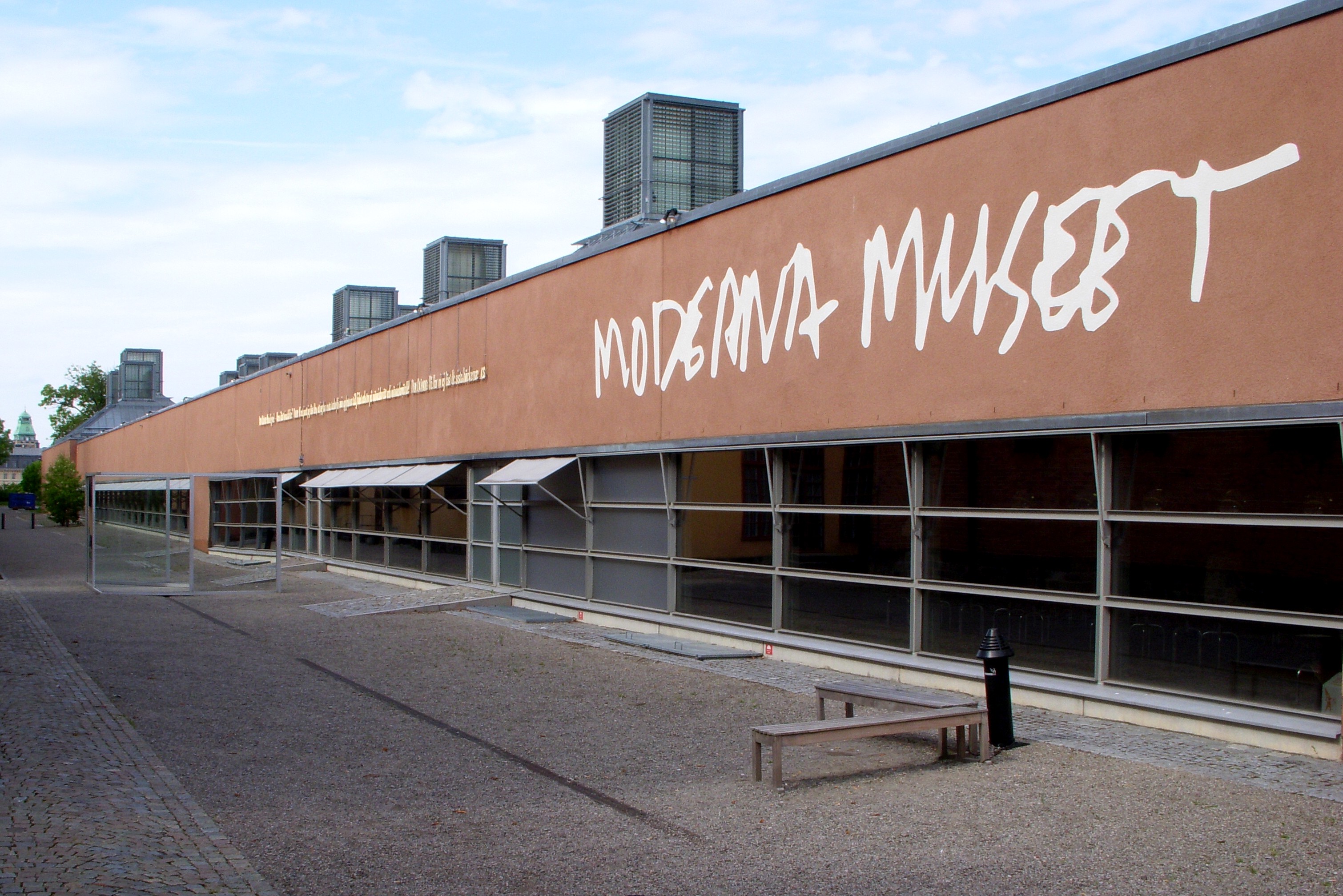 Moderna Museets terrakottafärgade fasad med museets handskrivna logotyp på Skeppsholmen