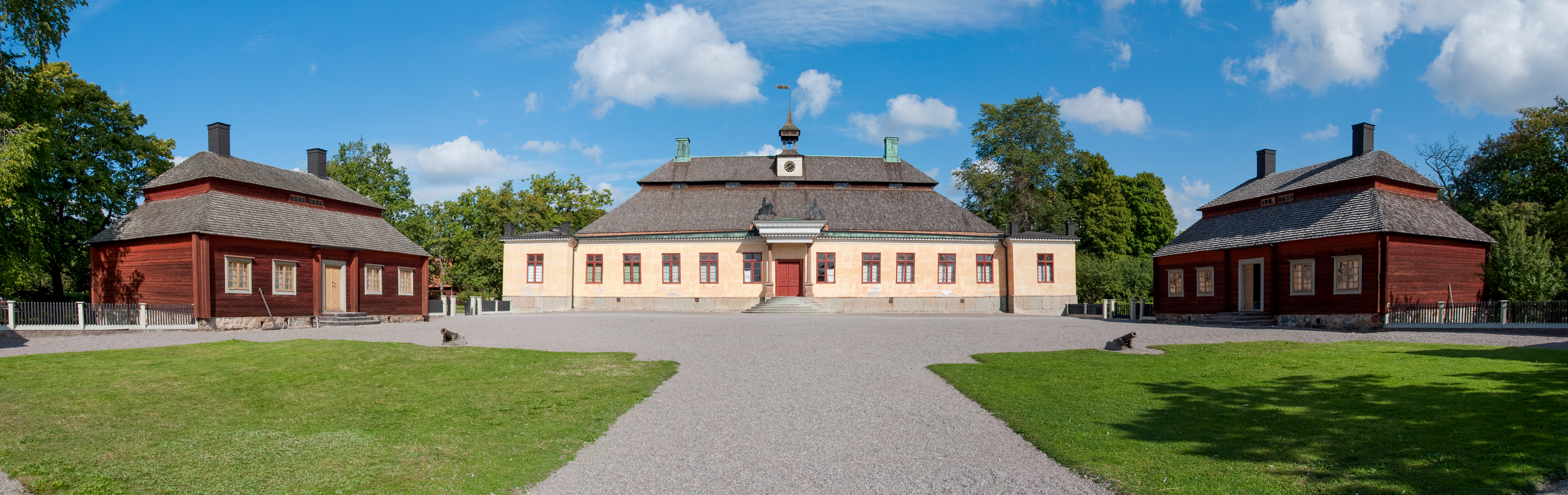 Skogaholms herrgård i falurött och pastellgult på friluftsmuseet Skansen en solig dag