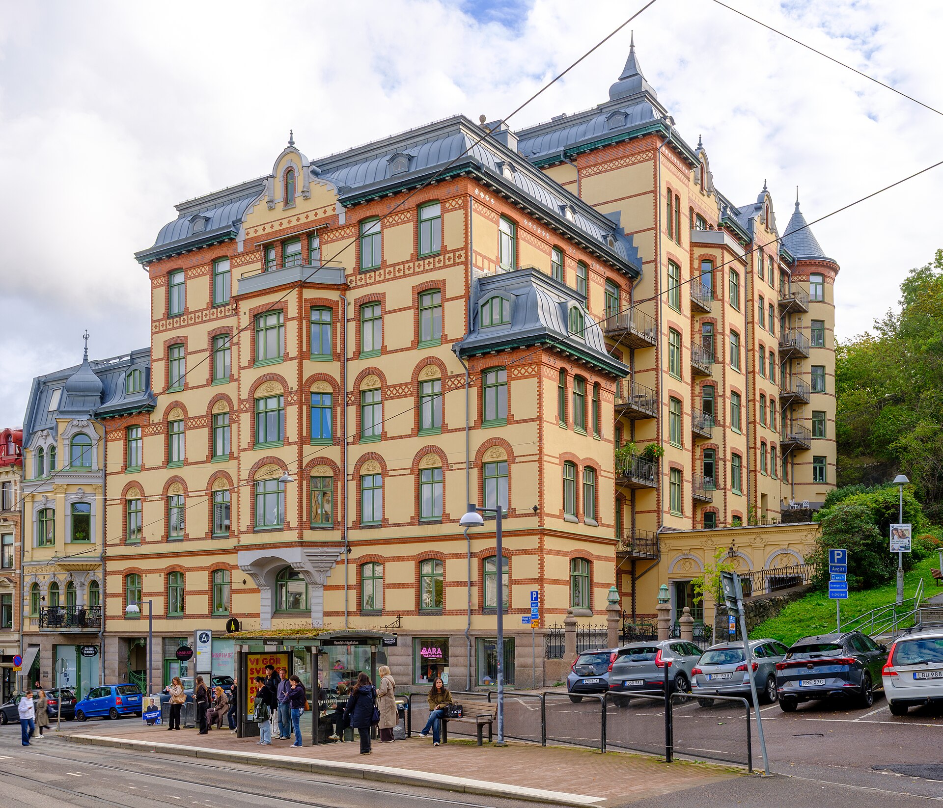 Sekelskifteshus vid Haga Nygatan i Göteborg med småbutiker i gatuplanet och en spårvagnshållplats framför