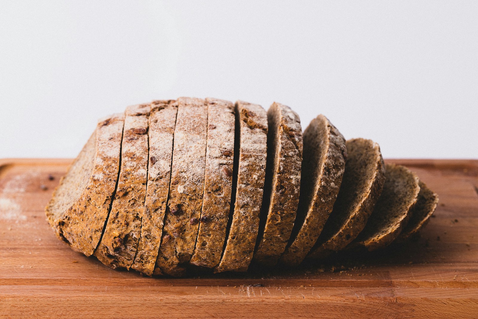Ett grovt formbröd uppskuret i skivor på en träskärbräda