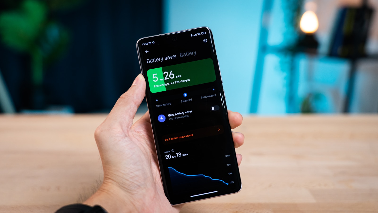 Hand som håller upp en telefon med batteristatistik på skärmen