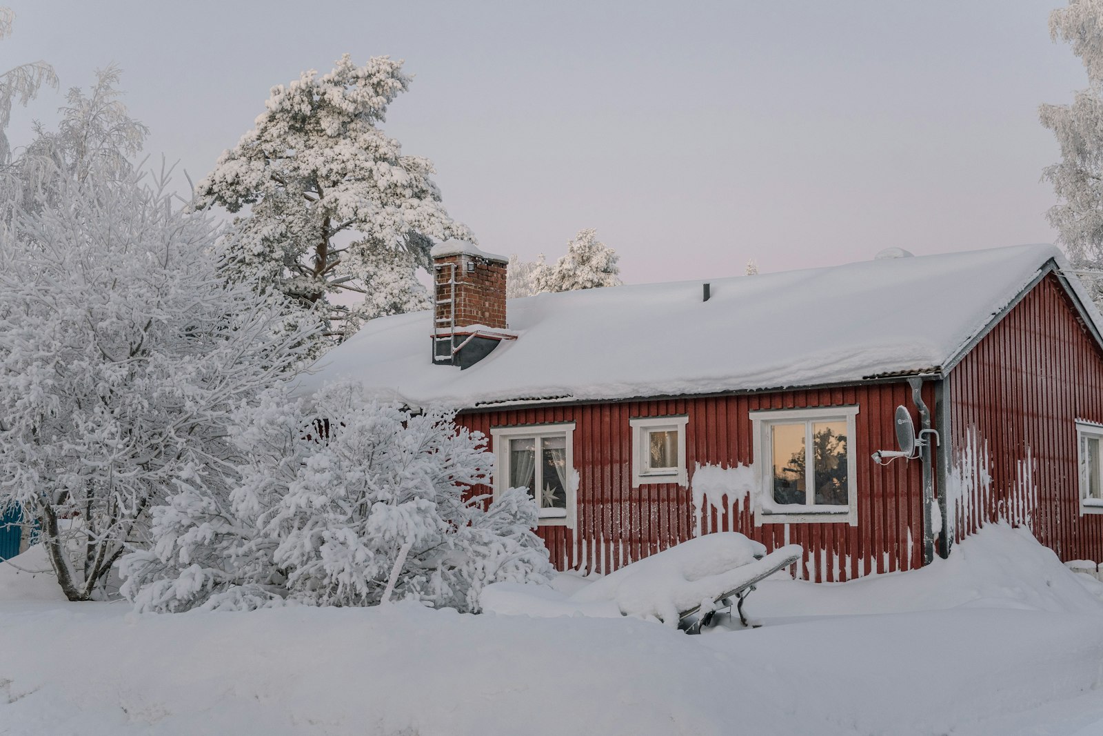 Red wooden house covered in snow in northern Sweden