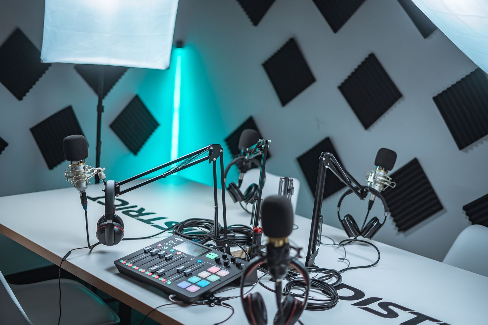 Poddstudio med svarta akustikpaneler pa vaggen, mikrofoner och mixerbord
