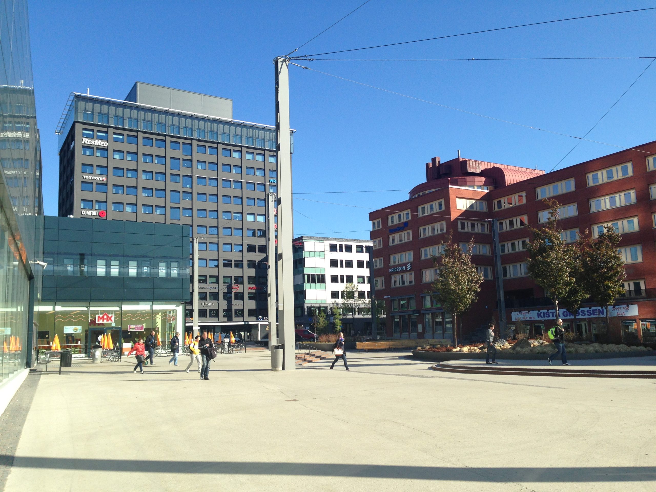 Jan Stenbecks torg i Kista en solig dag med människor i rörelse