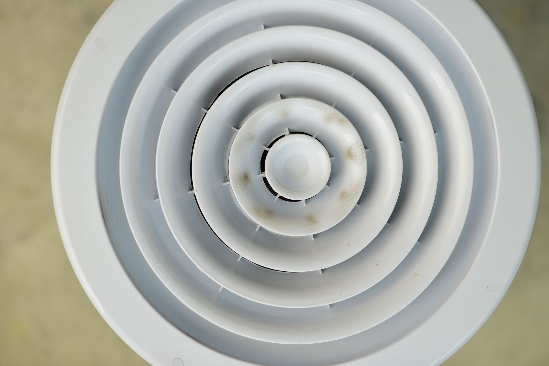 Runt vitt ventilationsdon i tak med smutsfläckar på de inre ringarna