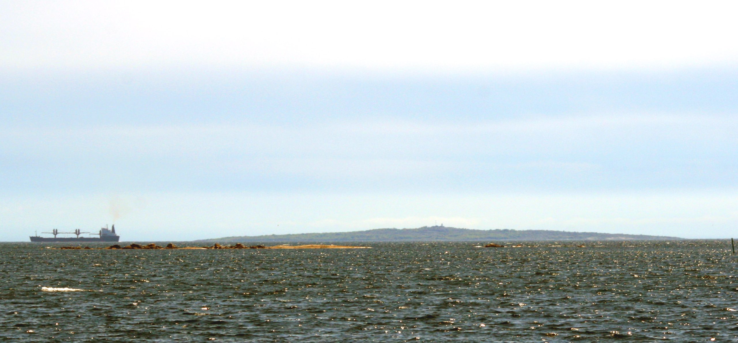 Ön Hanö sedd över vattnet i Hanöbukten under molnig himmel