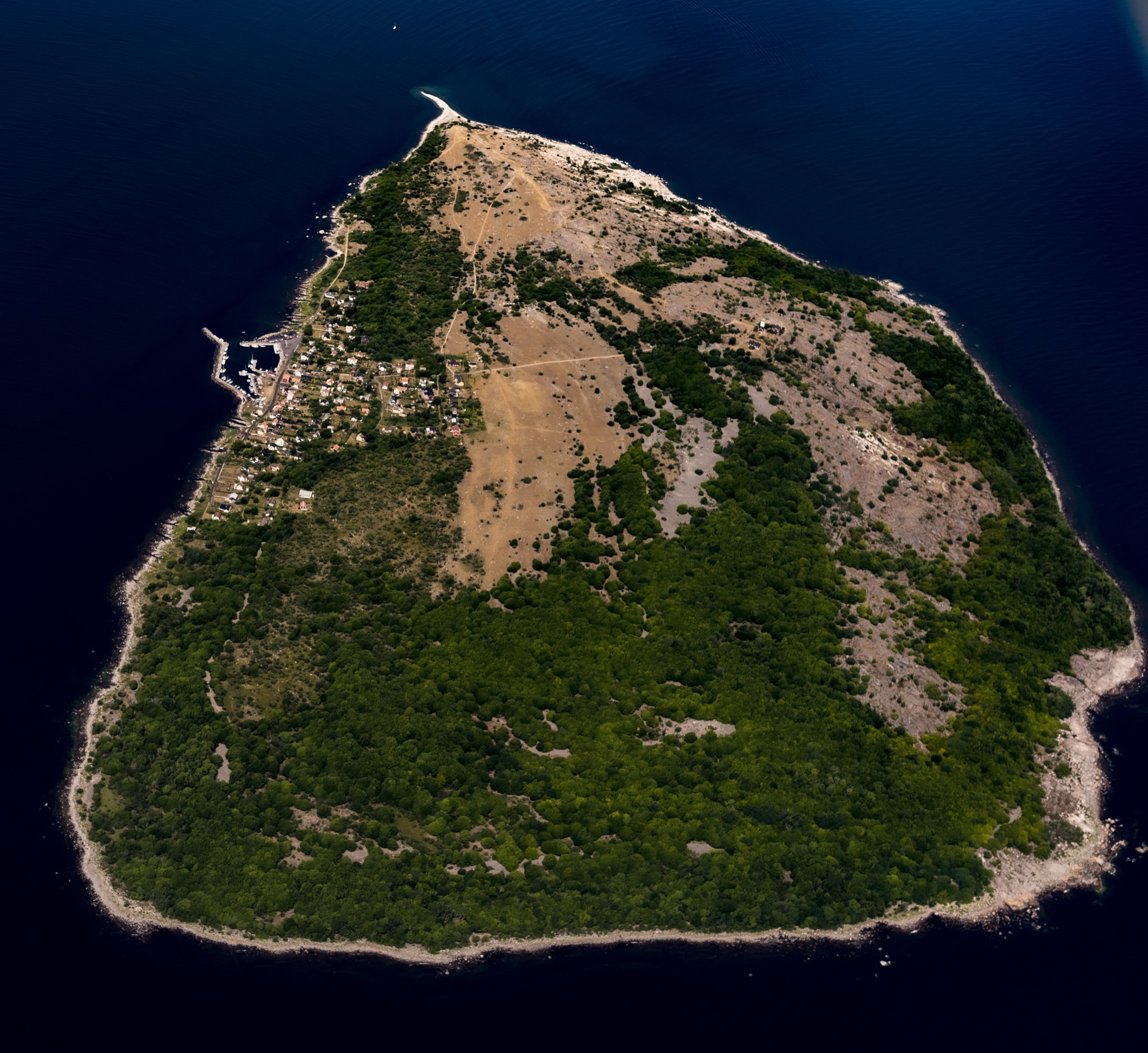 Flygfoto över Hanö med husklustret vid hamnen och obebyggd natur på resten av ön
