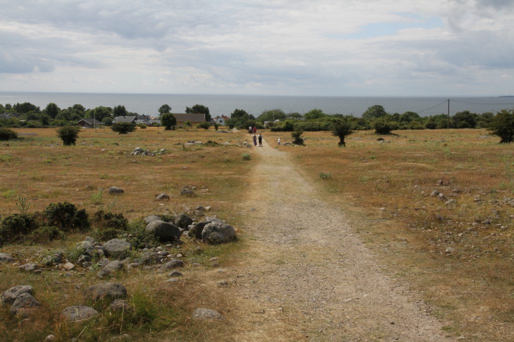 Grusstigen Fyrvägen på Hanö går genom öppen stenig hedmark med havet i bakgrunden