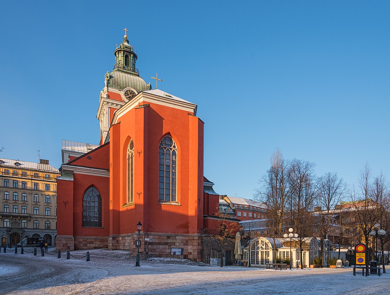 Sankt Jacobs kyrka med röd fasad och grön kopparkupol i vinterljus