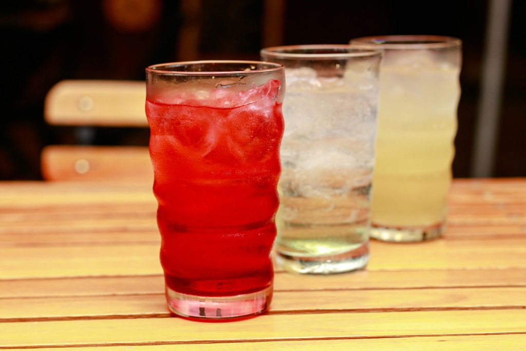 Högt glas med röd saft och is