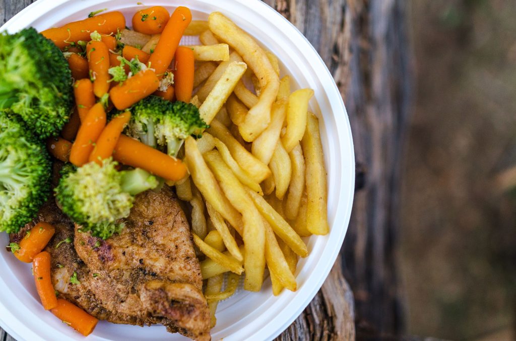 Tallrik med kött, pommes frites, broccoli och morötter