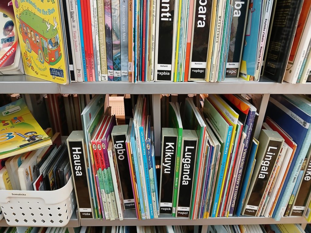 Barnböcker på hausa, igbo, lingala och andra språk i bibliotekets hyllor