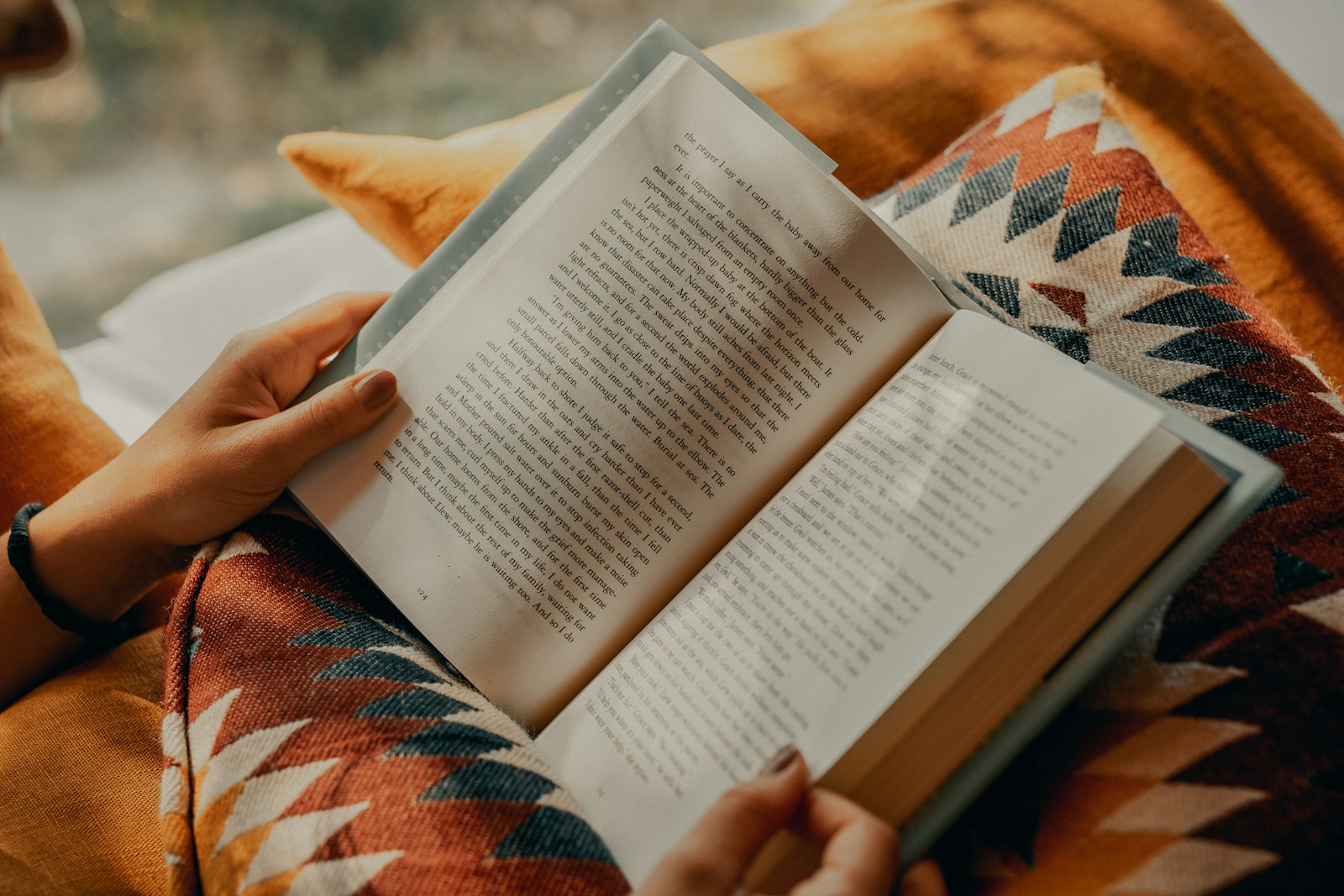 Person som läser en bok inlindad i en varm filt