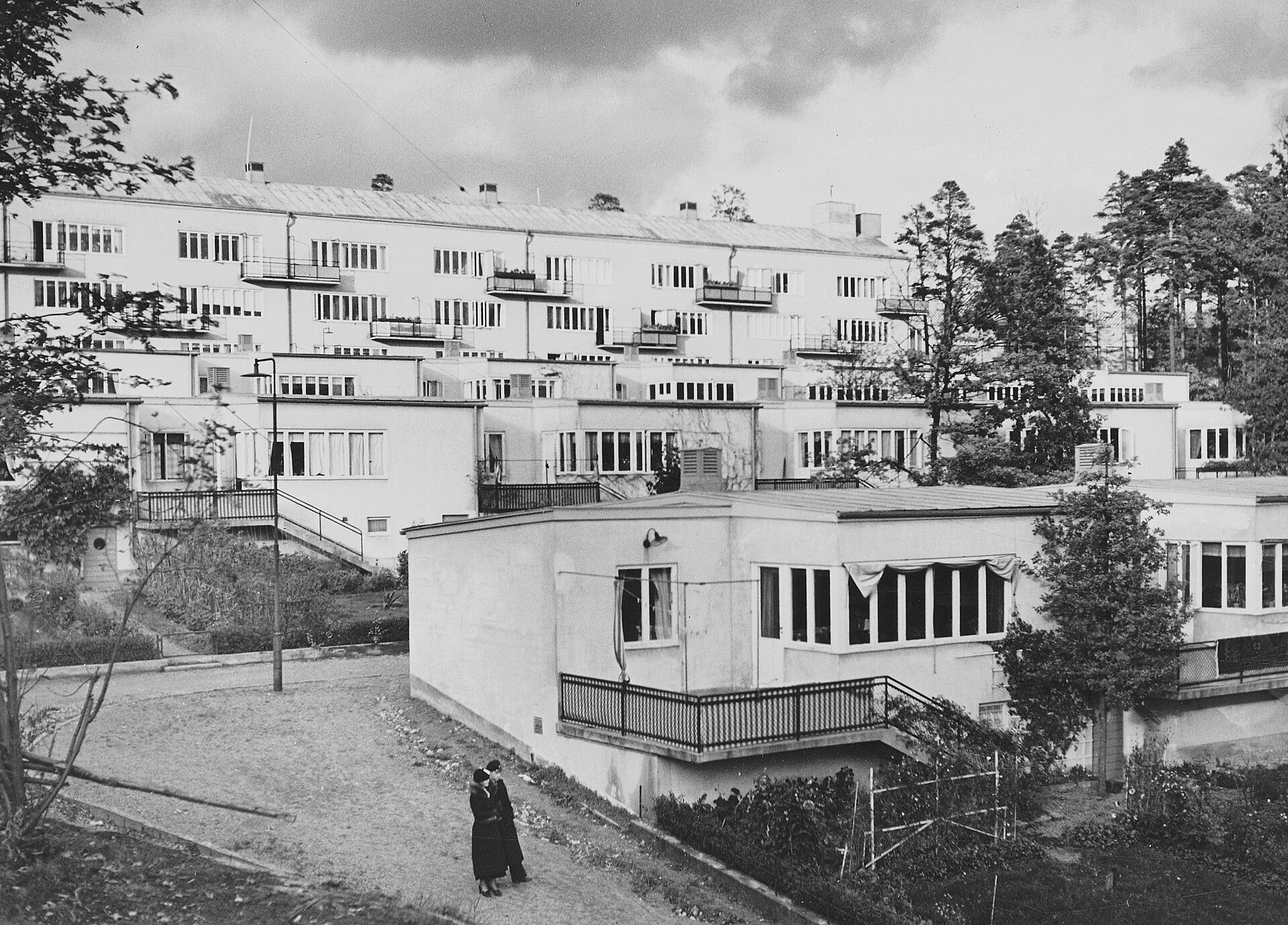 Kvarnholmens funktionalistiska radhus i terrasser nedför sluttningen med smalhuset i bakgrunden, 1940-talet