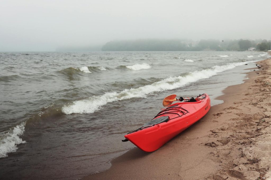 Kajak i vågor vid kust