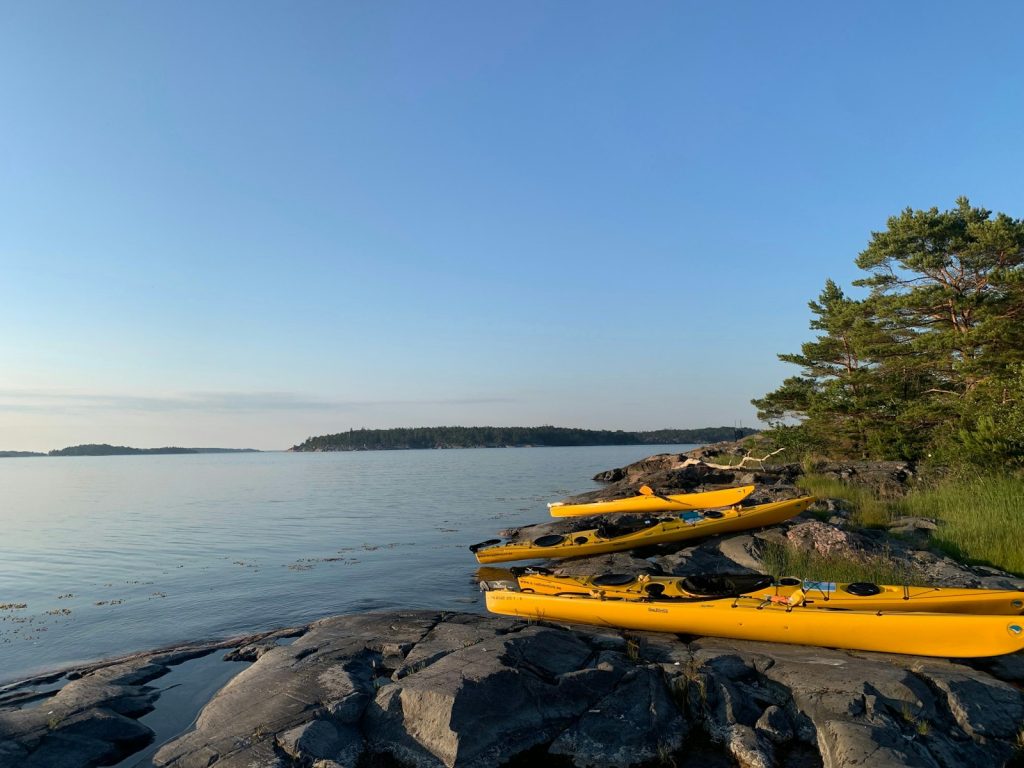 Gula havskajaker uppdragna på en klipphäll i skärgården