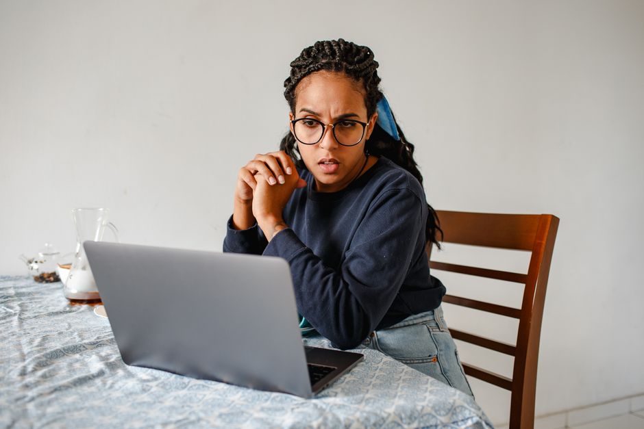 Kvinna vid laptop som väger olika alternativ mot varandra