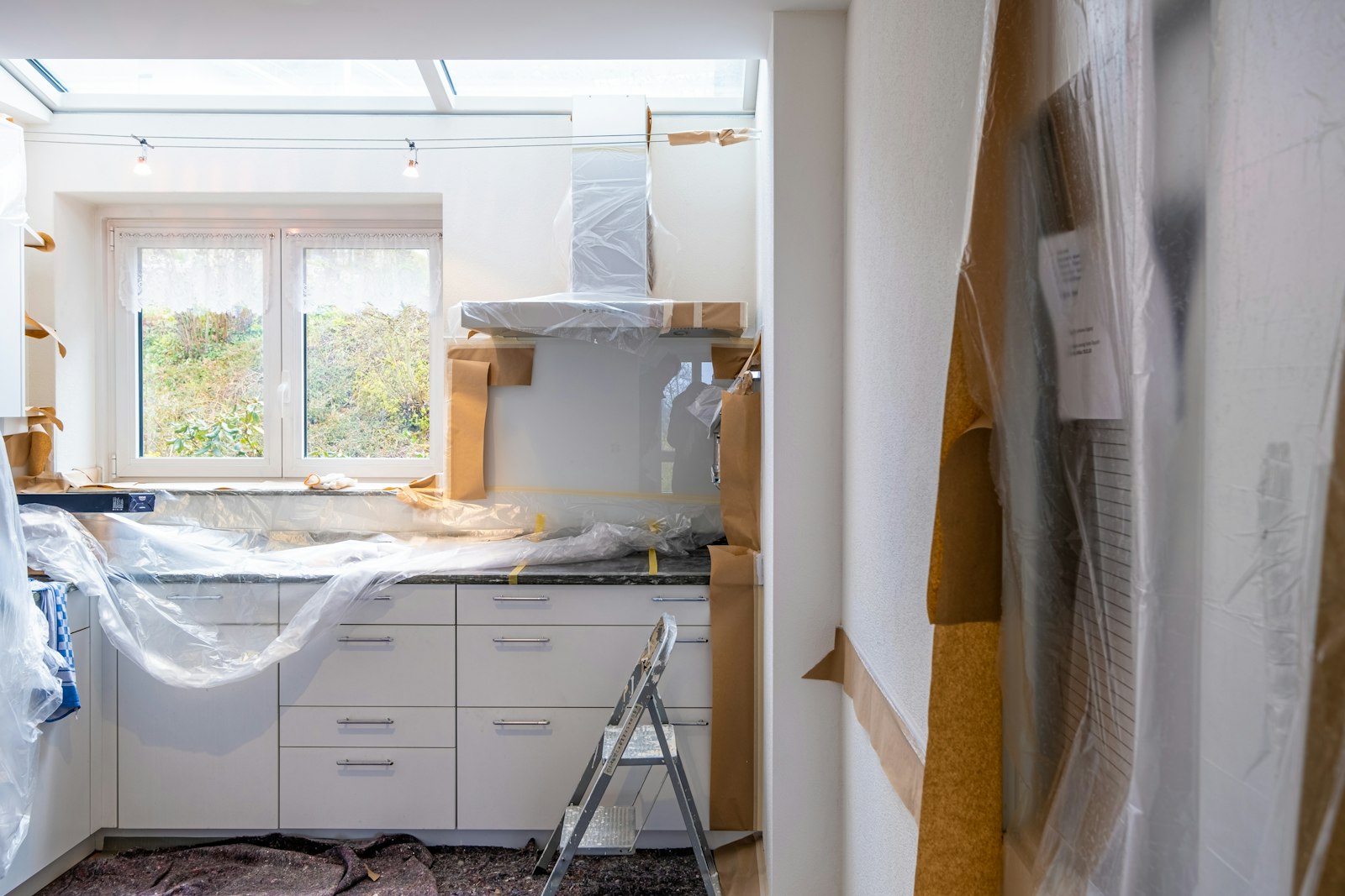 Kök under renovering med inplastade skåp och bänkskiva