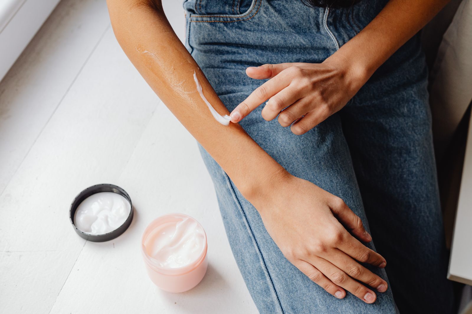 Person smörjer in fuktkräm på underarmen, vanlig åtgärd vid psoriasis
